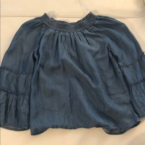 A girls off the shoulder jean colored shirt